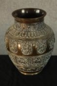 An early 20th century Indian cast brass baluster vase, with incised panels of mythical creature