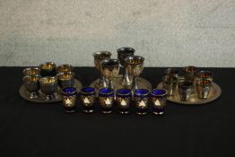 Three 20th century silver plate and pewter liqueur sets, together with six blue glass and gold