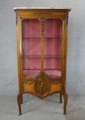 An early 20th century carved French Kingswood and marble topped single door display cabinet, opening