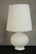 A contemporary white glass table lamp raised on spherical bulbus base. H.53cm.