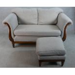 A 20th century mahogany framed two seater scroll arm settee upholstered in grey fabric raised on