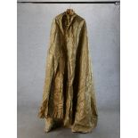 A 20th century gold silk theatrical cloak. H.180 W.80cm