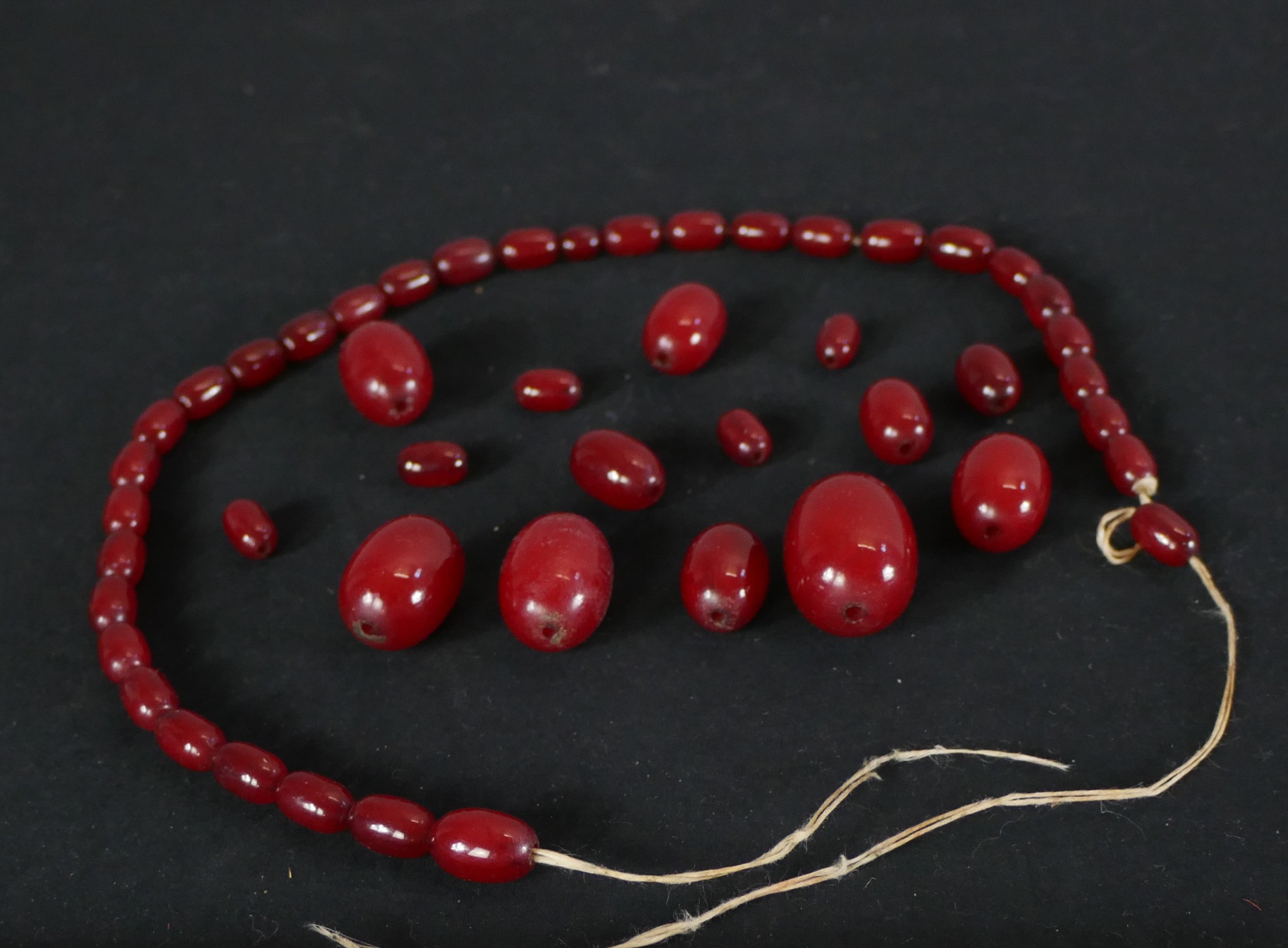 A cherry amber Bakelite graduated bead necklace. (broken) Largest bead L.3cm. - Image 2 of 3