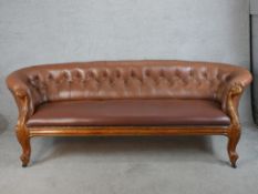 A 19th century mahogany framed brown leather button back settee raised on carved cabriole supports