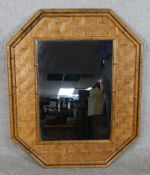 A contemporary Chinese bamboo and wicker octagonal wall hanging mirror. H.88 W.73cm