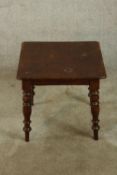 A late 19th century stained mahogany square topped table raised on four turned outswept supports.