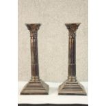 A pair of George V hallmarked silver Corinthian candlesticks, Birmingham 1972, raised on stepped