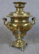 An early 20th century brass twin handled samovar raised on square foot terminating in four hoof