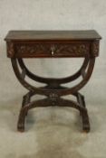 A 19th century Italian style carved oak single drawer side table raised on double 'X' supports