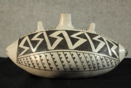 A contemporary Clint Swink white painted pottery fish decorated with black geometric patterns,