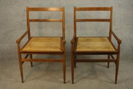 A pair of mid 20th century beech framed ladder back carver dining chairs with cane seats, raise