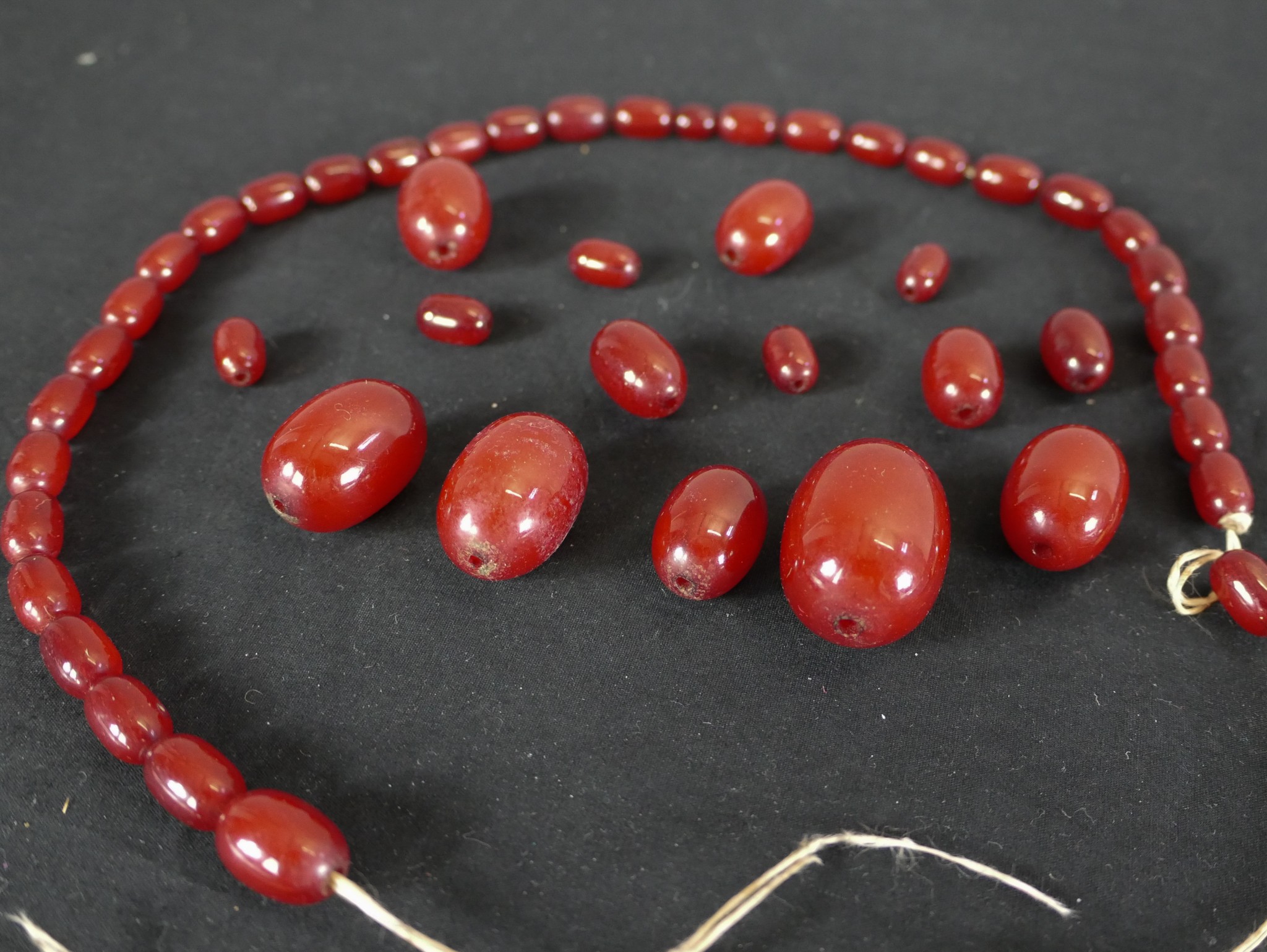 A cherry amber Bakelite graduated bead necklace. (broken) Largest bead L.3cm. - Image 3 of 3