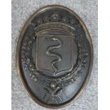 A 19th century cast bronze oval heraldic wall hanging plaque depicting a serpent in a shield under a