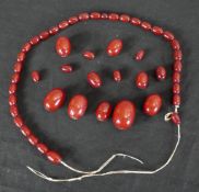 A cherry amber Bakelite graduated bead necklace. (broken) Largest bead L.3cm.