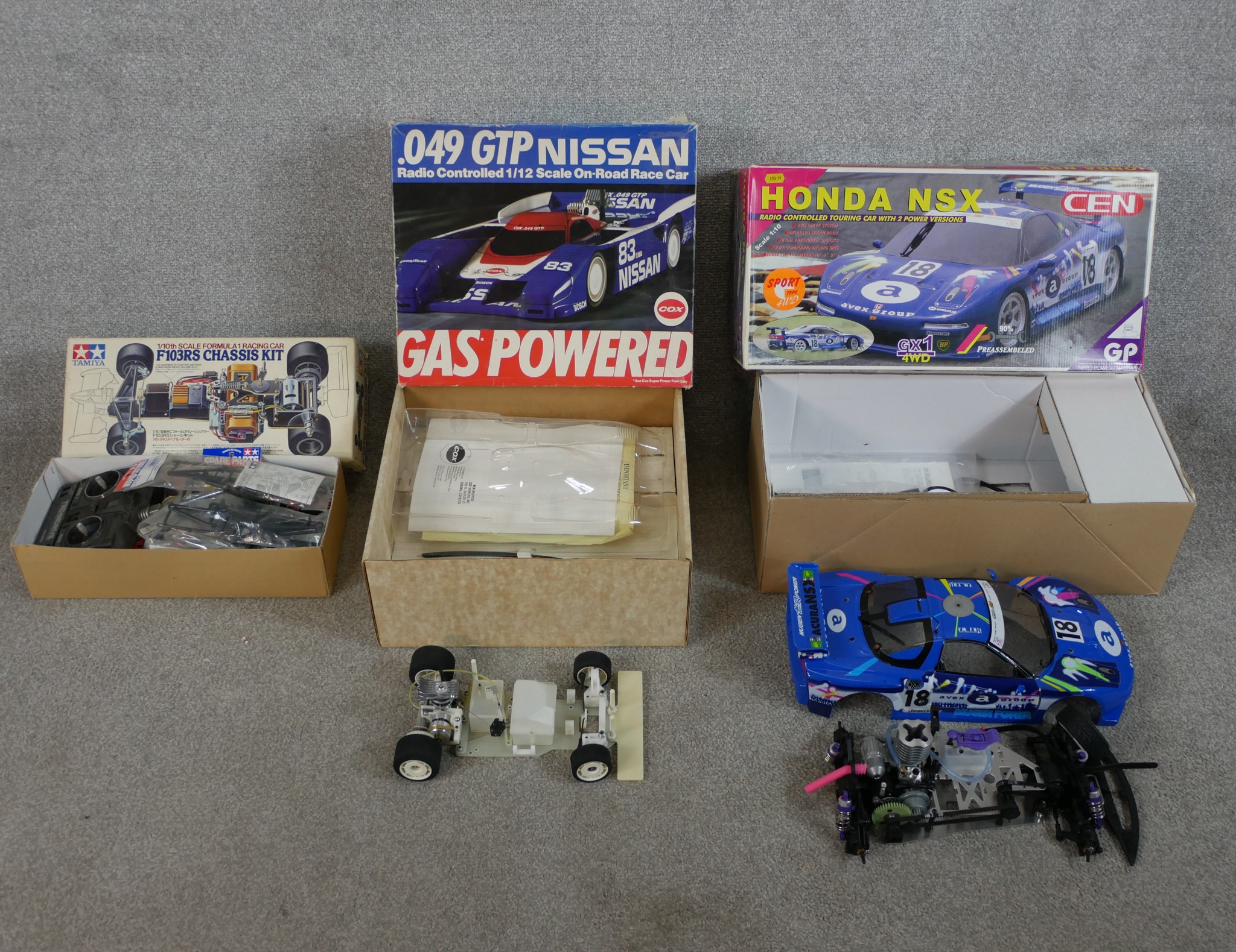 Three boxed scale model cars to include Tamiya 1:10 F103RS Chassis kit, Nissan 93 Cox racing car &