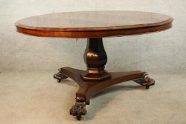 A William IV mahogany circular topped dining table with hexagonal central column standing on triform