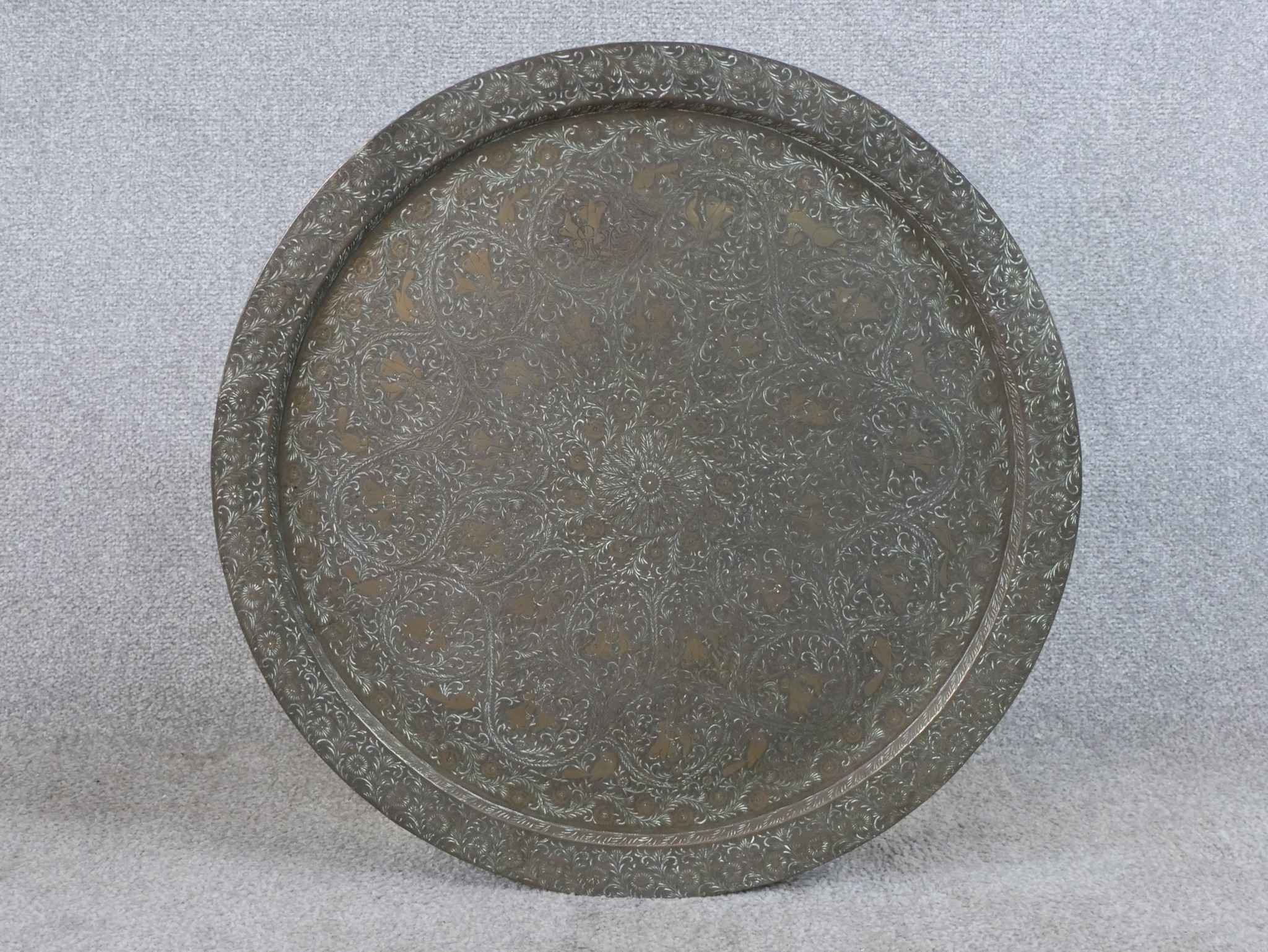 A 20th century engraved, possibly Moroccan circular brass charger with all over engraved decoration.