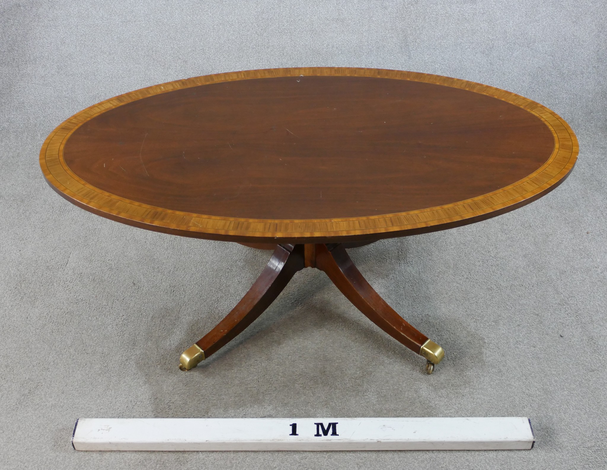 A Regency style inlaid mahogany oval coffee table raised on turned central column on four outswept - Image 4 of 6
