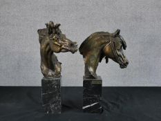 Two contemporary bronzed horse heads, each raised on black marble plinths with applied brass plaques