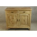 An early 20th century pine two drawer over two door cupboard raised on turned feet. H.95 W.110 D.
