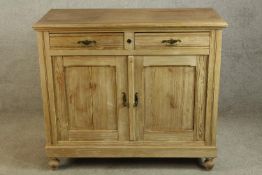An early 20th century pine two drawer over two door cupboard raised on turned feet. H.95 W.110 D.