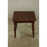 A late 19th century stained mahogany square topped table raised on four turned outswept supports.