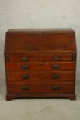 A George III oak fall front bureau with fitted interior, raised on two short over three long drawers