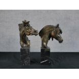 Two contemporary bronzed horse heads, each raised on black marble plinths with applied brass plaques