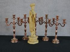 A set of four silver plated twin branch candle sticks with turned central column raised on