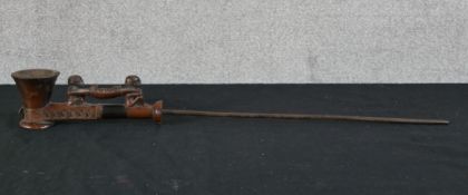 A late 19th/early 20th century African carved wooden opium pipe in the form two figures carrying a