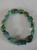 A string of fourteen large turquoise beads and nuggets, the largest bead 4.2cm in length. Length