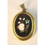 An early 20th century rolled gold framed pietra dura pendant with floral design.