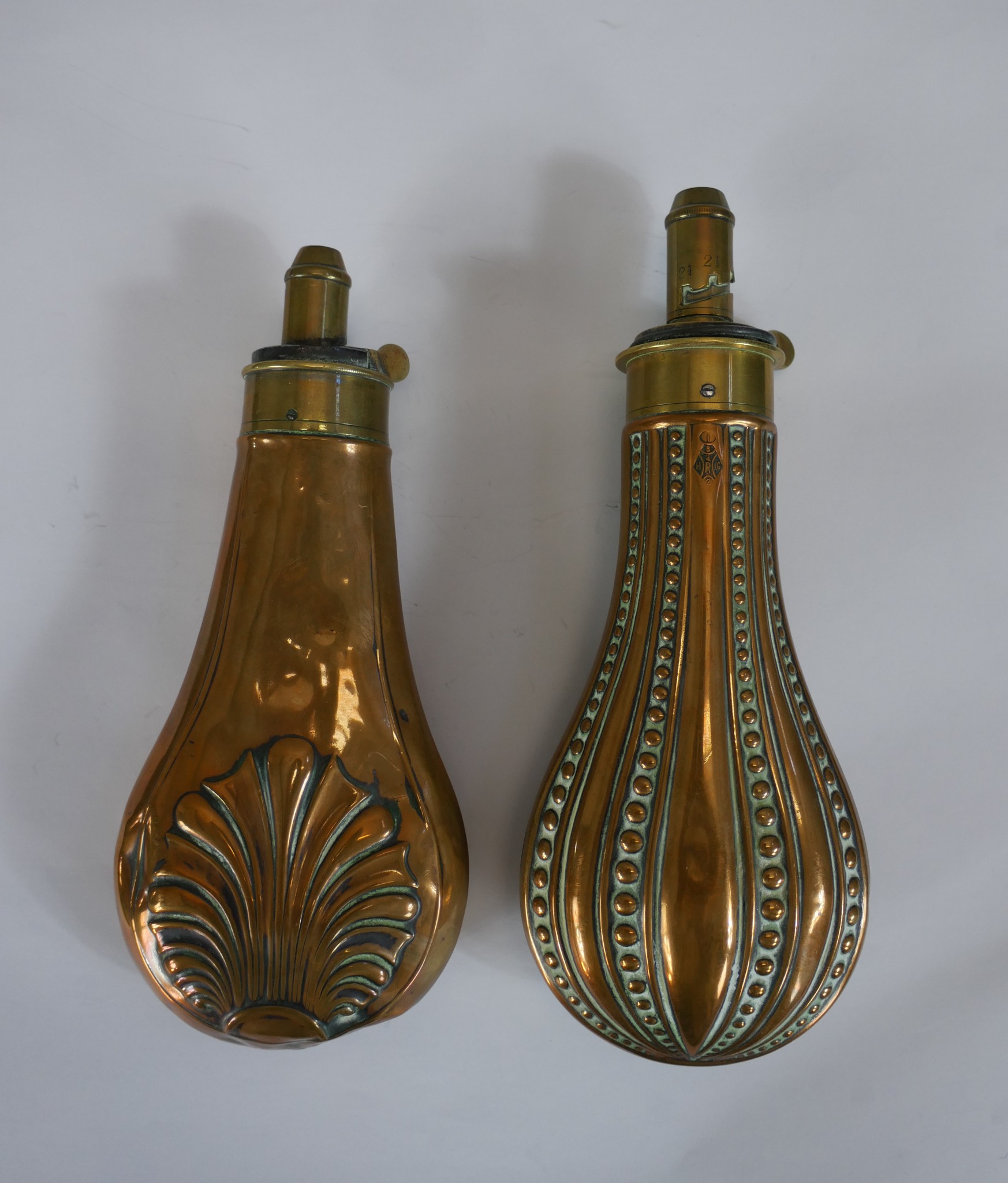 Two late 19th/early 20th century James Dixon & Sons embossed copper and brass powder flasks. H.21