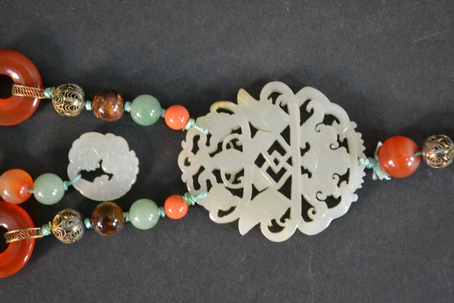 A boxed long ceremonial necklace silver gilt, jade, coral, carnelian and tigers eye pendant - Image 4 of 8