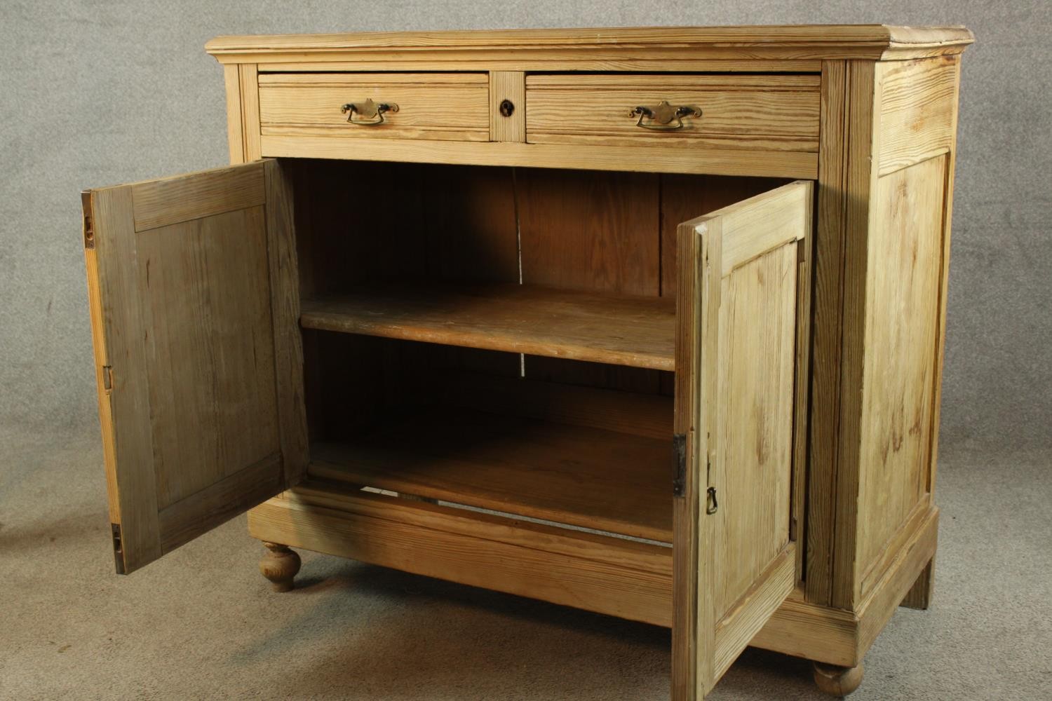 An early 20th century pine two drawer over two door cupboard raised on turned feet. H.95 W.110 D. - Image 3 of 4