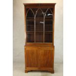 A 19th century mahogany bookcase with single glass panelled door above two cupboard door base
