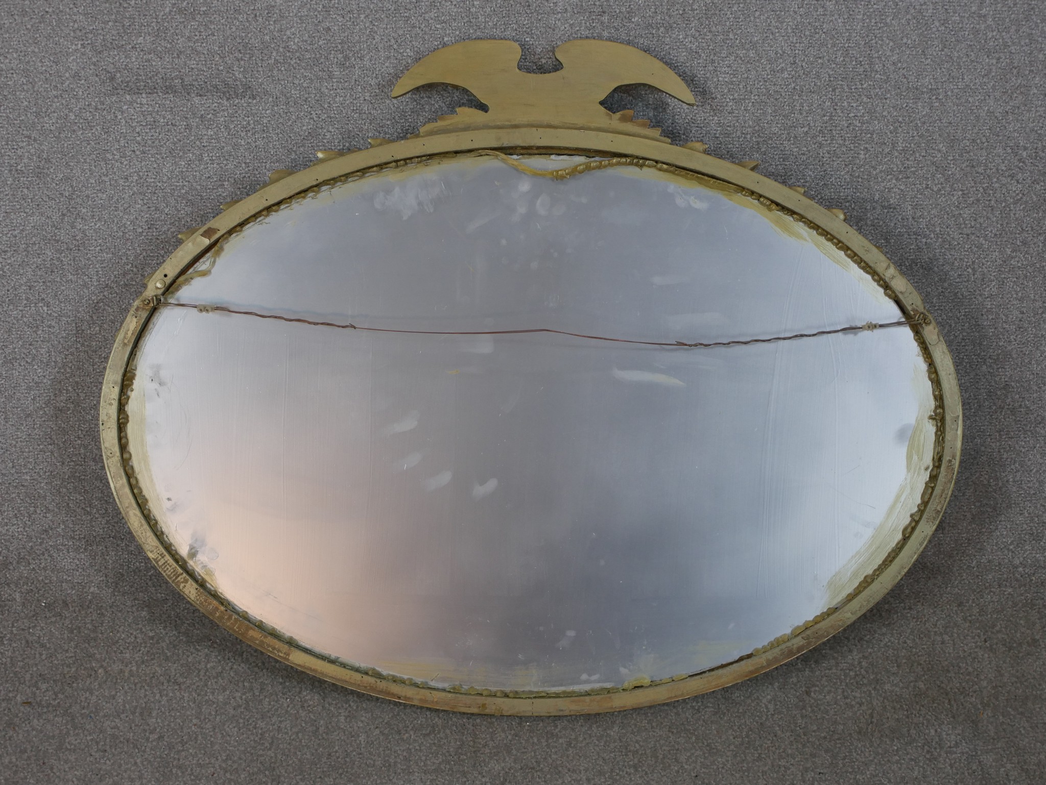 A 20th century oval gilt framed mirror mounted with leaf and eagle decoration. H.77 W.96cm - Image 3 of 3