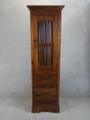 A late 20th century Indonesian teak single door food cupboard with four drawers below raised on