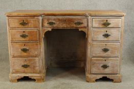 A 20th century limed hardwood twin pedestal desk with central drawer and twin pedestals each with