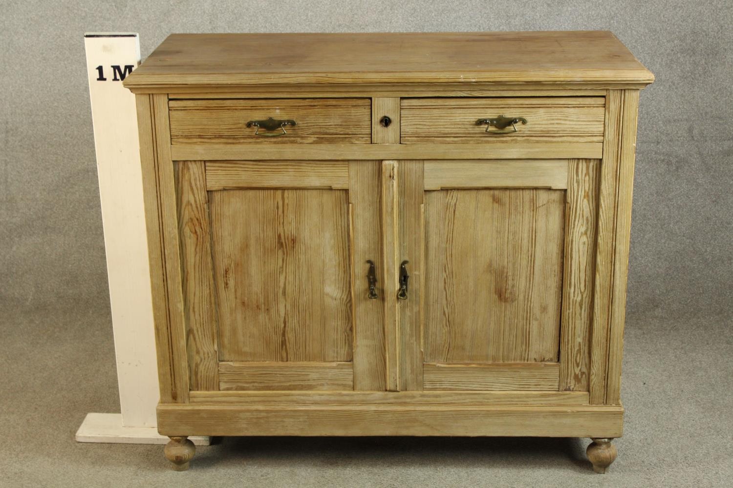 An early 20th century pine two drawer over two door cupboard raised on turned feet. H.95 W.110 D. - Image 2 of 4