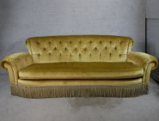 A 19th century gold upholstered button back scroll arm three person sofa. H.88 W.240 D.100cm