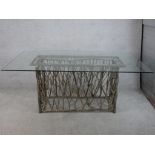 A contemporary glass topped table raised on modernist rectangular twig base. H.77 W.180 D.100cm