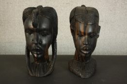 Two large mid century heavy carved African Tribal hardwood heads of warriors, one male and one