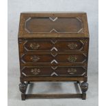 An early 20th century oak fall front bureau, opening to reveal fitted interior with three drawers