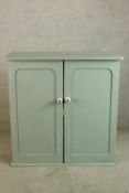 A contemporary painted pine twin door cabinet opening to reveal four shelves raised on plinth