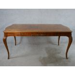 An early 20th century walnut and mahogany veneered pull out dining table raised on cabriole