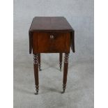 A 19th century mahogany drop leaf sewing table, with twin drawers to one end, raised on turned