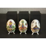A set of three contemporary Mirai Systems enamelled ceramic eggs, polychrome decorated, with lids,