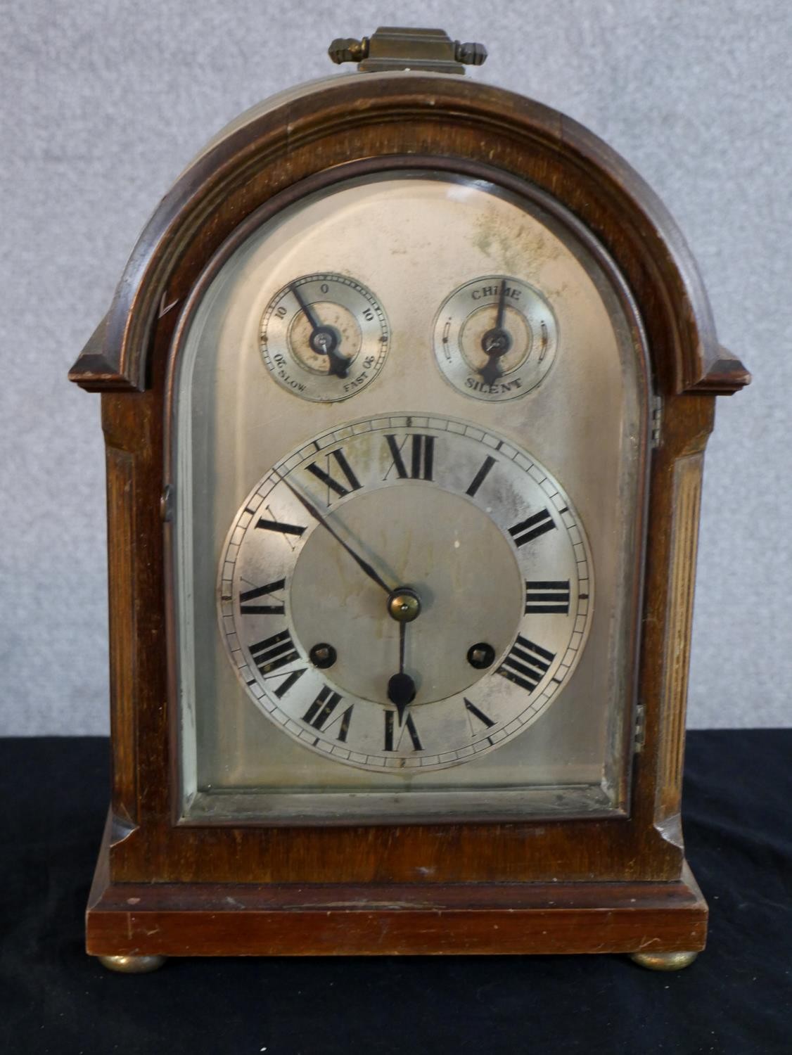 An early 20th century mahogany cased dome topped mantle clock, the silvered dial with two subsidiary