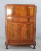 A 1930s walnut veneered drinks cabinet, the hinged lid opening to reveal fitted interior, with